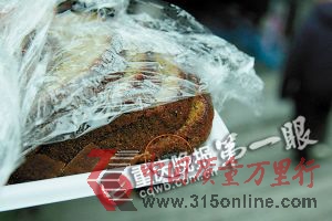 ■解開保鮮膜,蛋糕一角有顆耗子屎(紅圈處)。重慶晚報(bào)記者 陸綱 攝